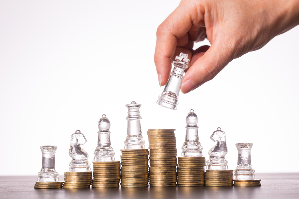 ruka a sachy symbolizujici investicni strategii