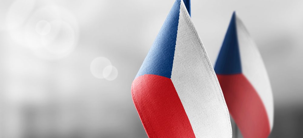 Malé státní vlajky Česka na světlém rozmazaném pozadí