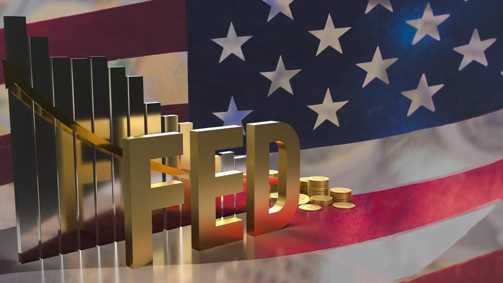 Zlatý text s iniciály FED a v pozadí vlajka USA