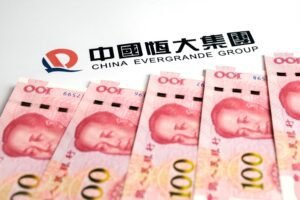 Čínské bankovky a logo společnosti China Evergrande Group.