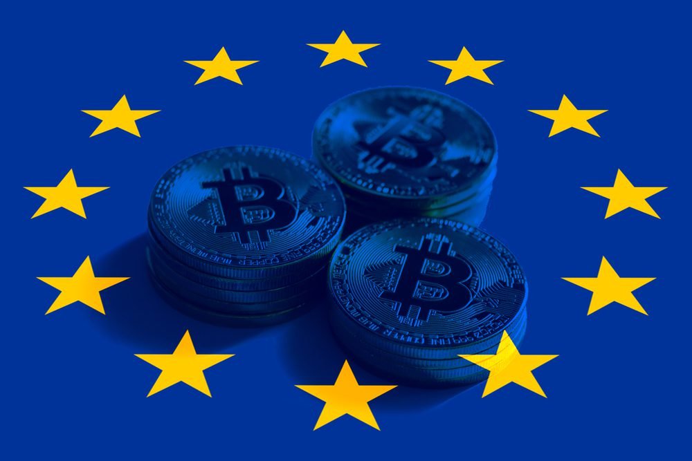 Vlajka EU překrývá Bitcoin v pozadí. Evropská unie a regulace kryptoměn